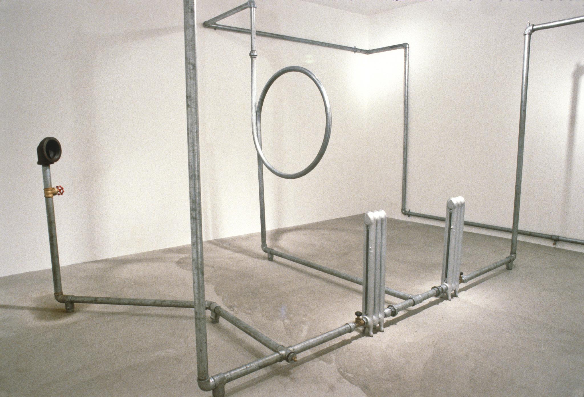 An installation of hot water pipes and gauges installed in a white walled gallery space