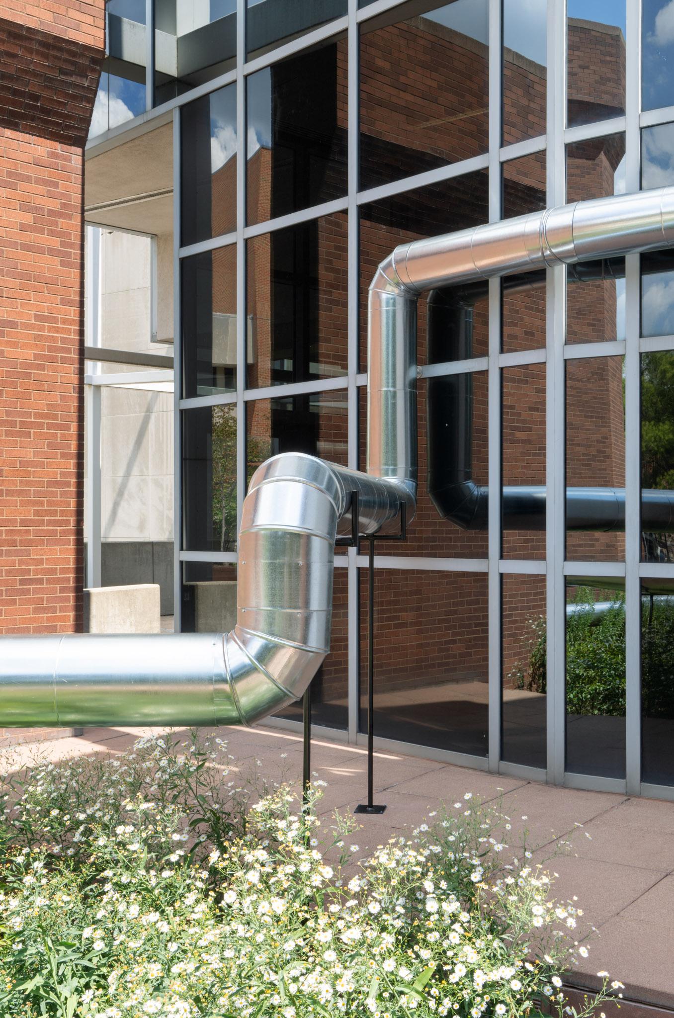 A network of steel duct winding outside a building