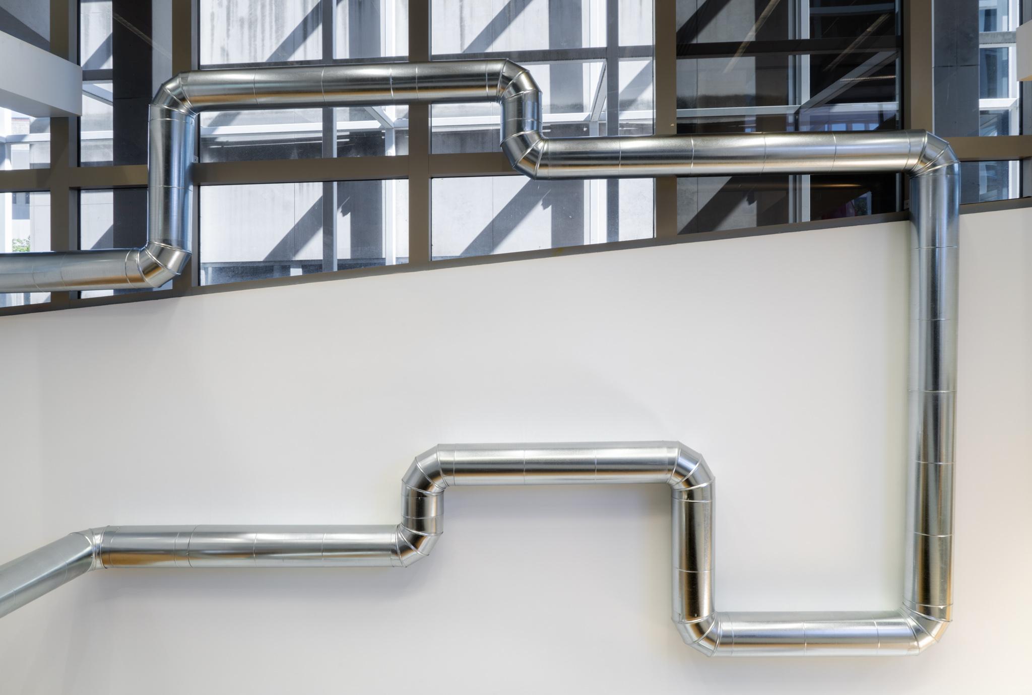 A network of steel duct winding through a building