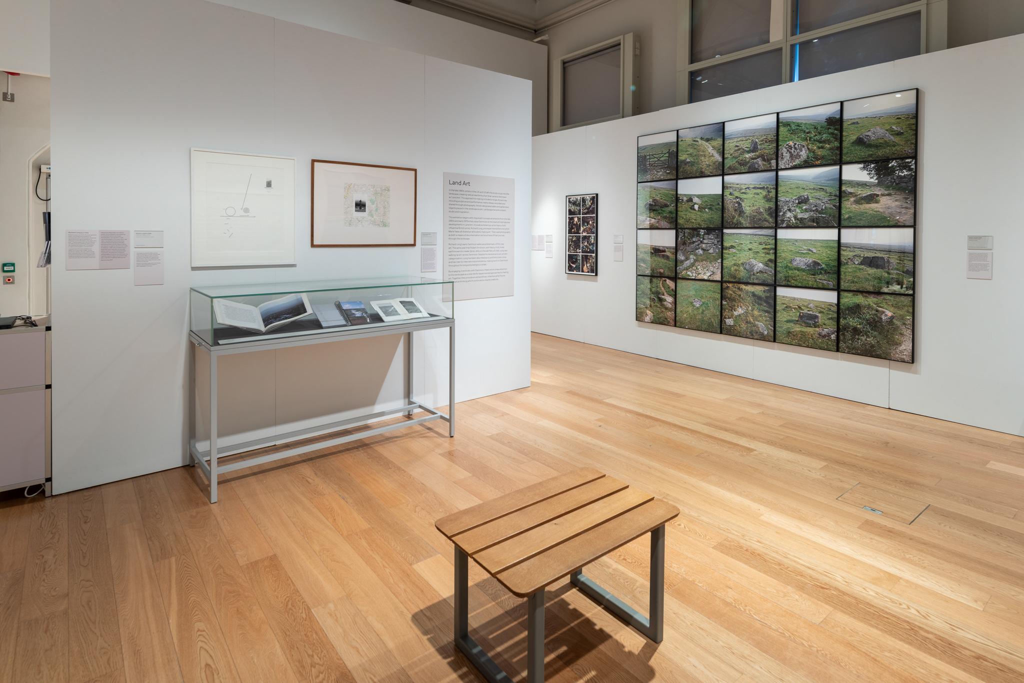Installation view of an exhibition featuring photographs and wall works