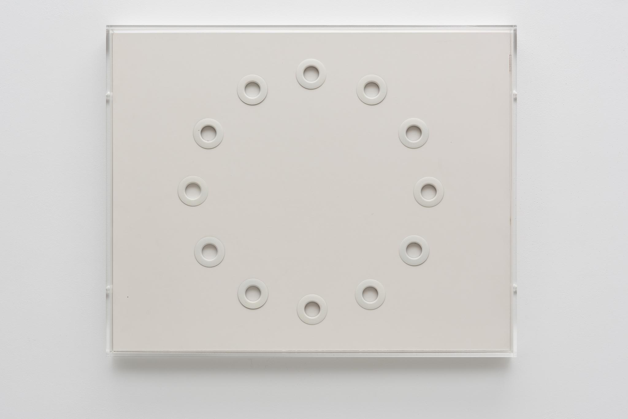 Circular white grommets arranged in a circle on white foamcore