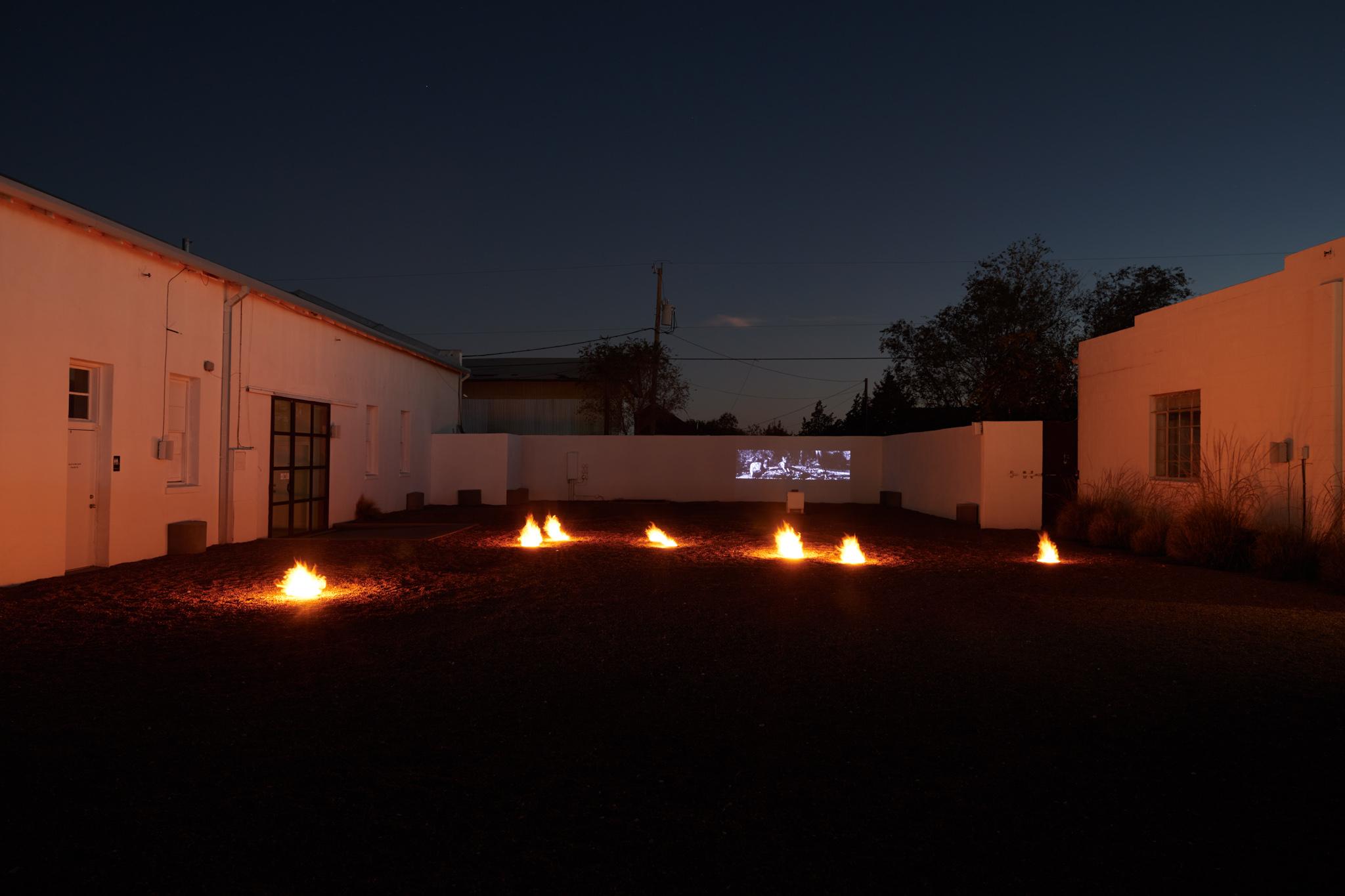 a courtyard with several small firepits in the ground spaced out in the shape of the big dipper