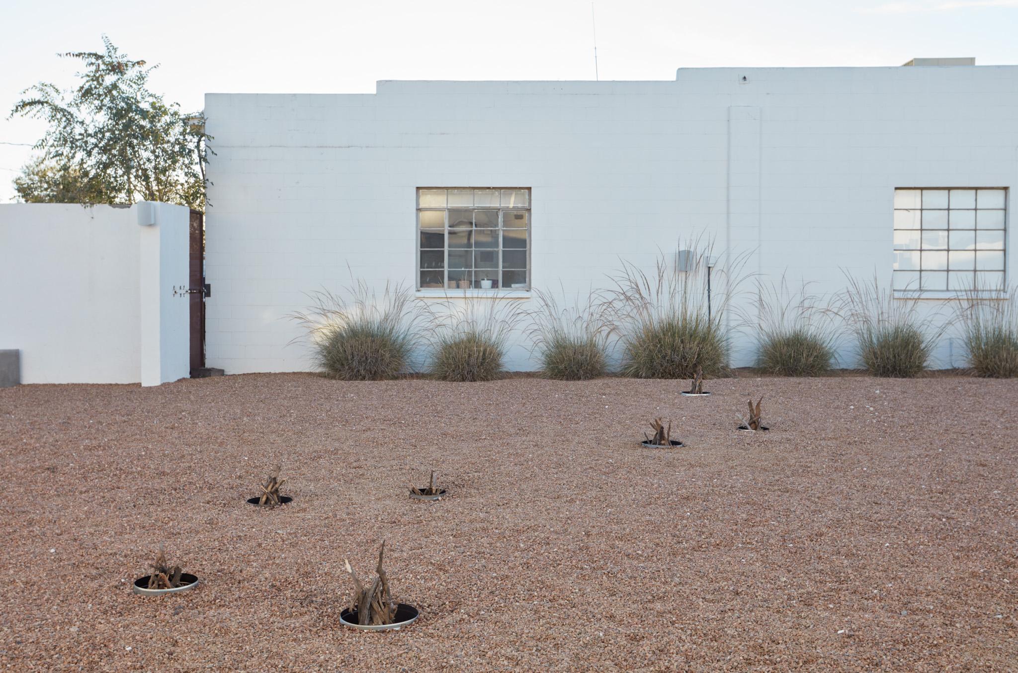 a courtyard with several small firepits in the ground spaced out in the shape of the big dipper