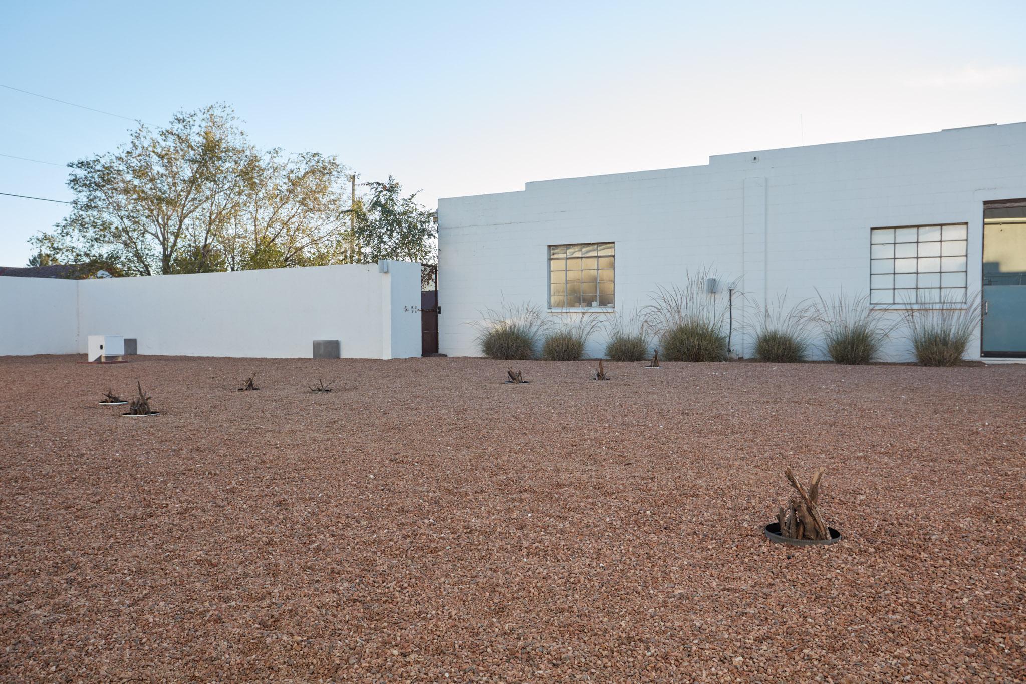 a courtyard with several small firepits in the ground spaced out in the shape of the big dipper