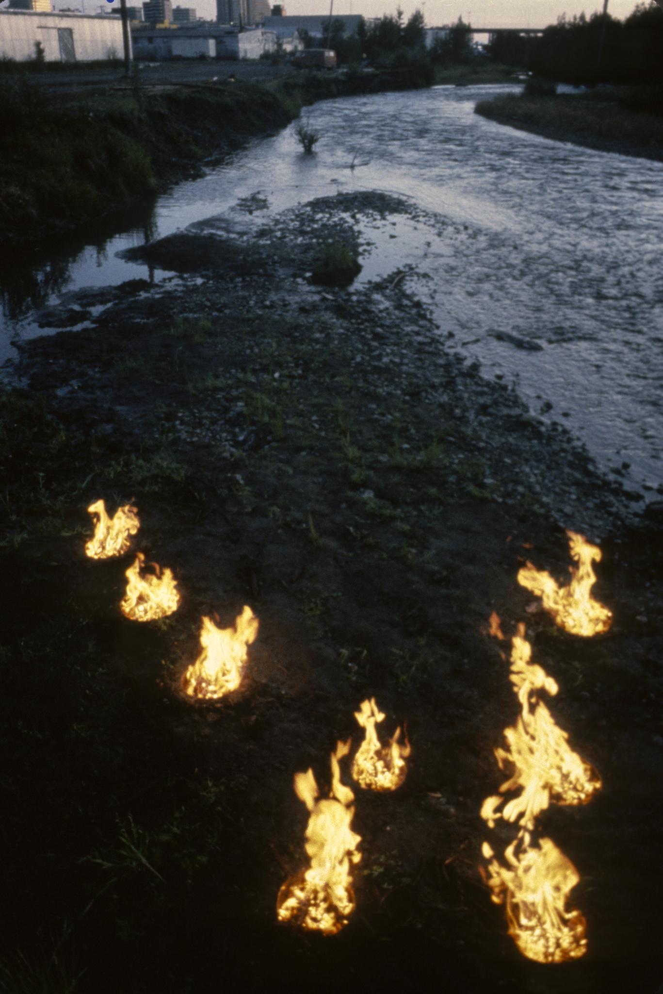 a small island in a river that has firepits arranged in the shape of the big dipper