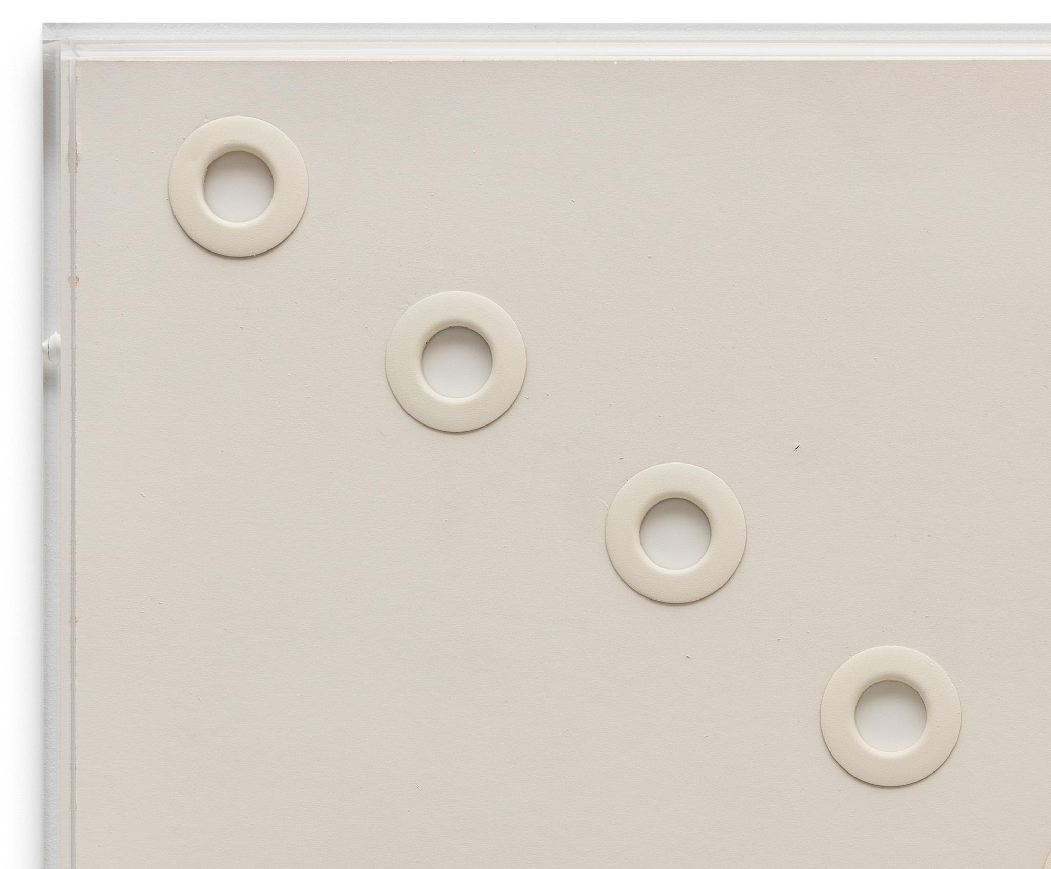white circular grommets through foamcore arranged in a diagonal line