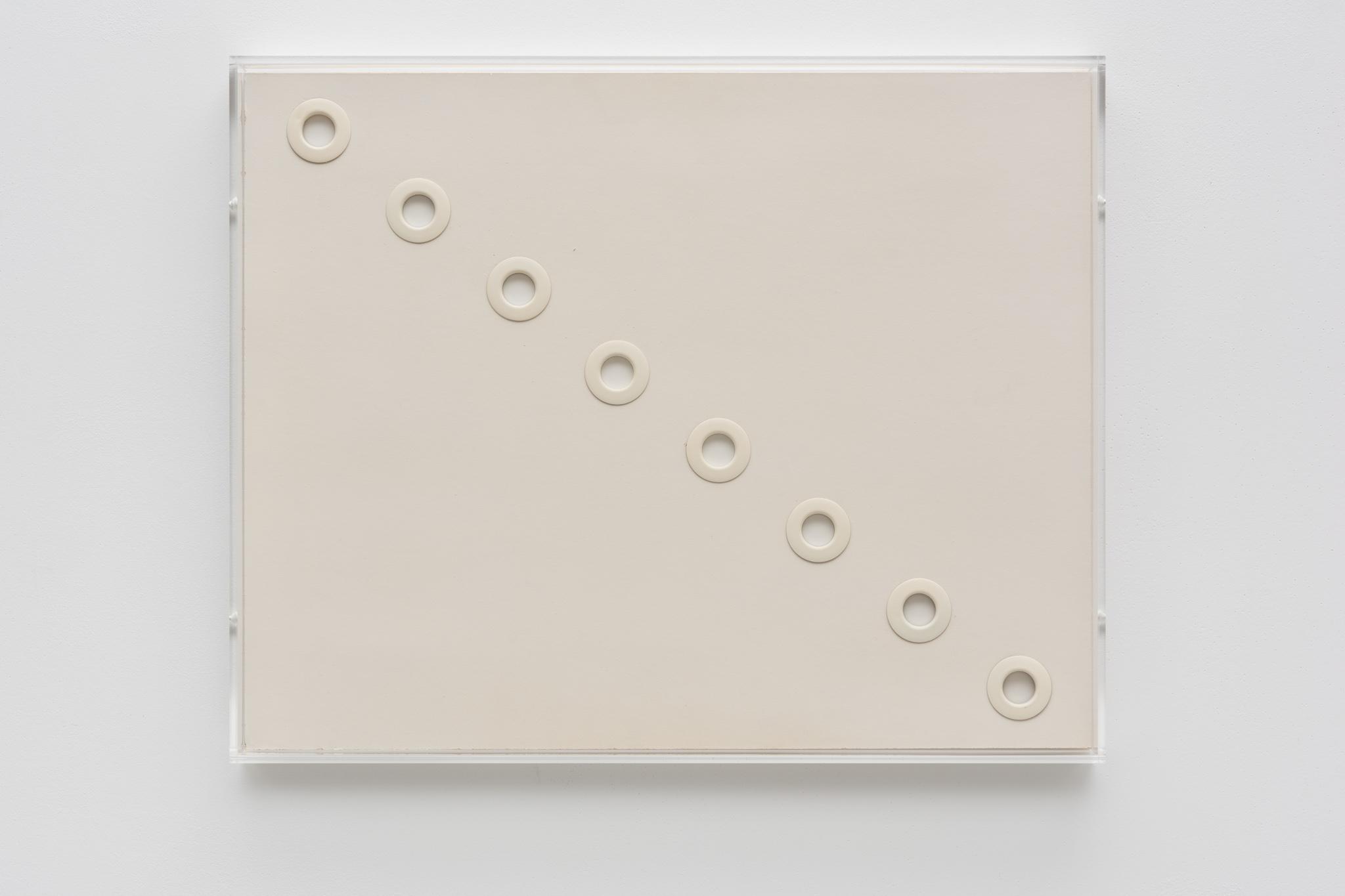 white circular grommets through foamcore arranged in a diagonal line