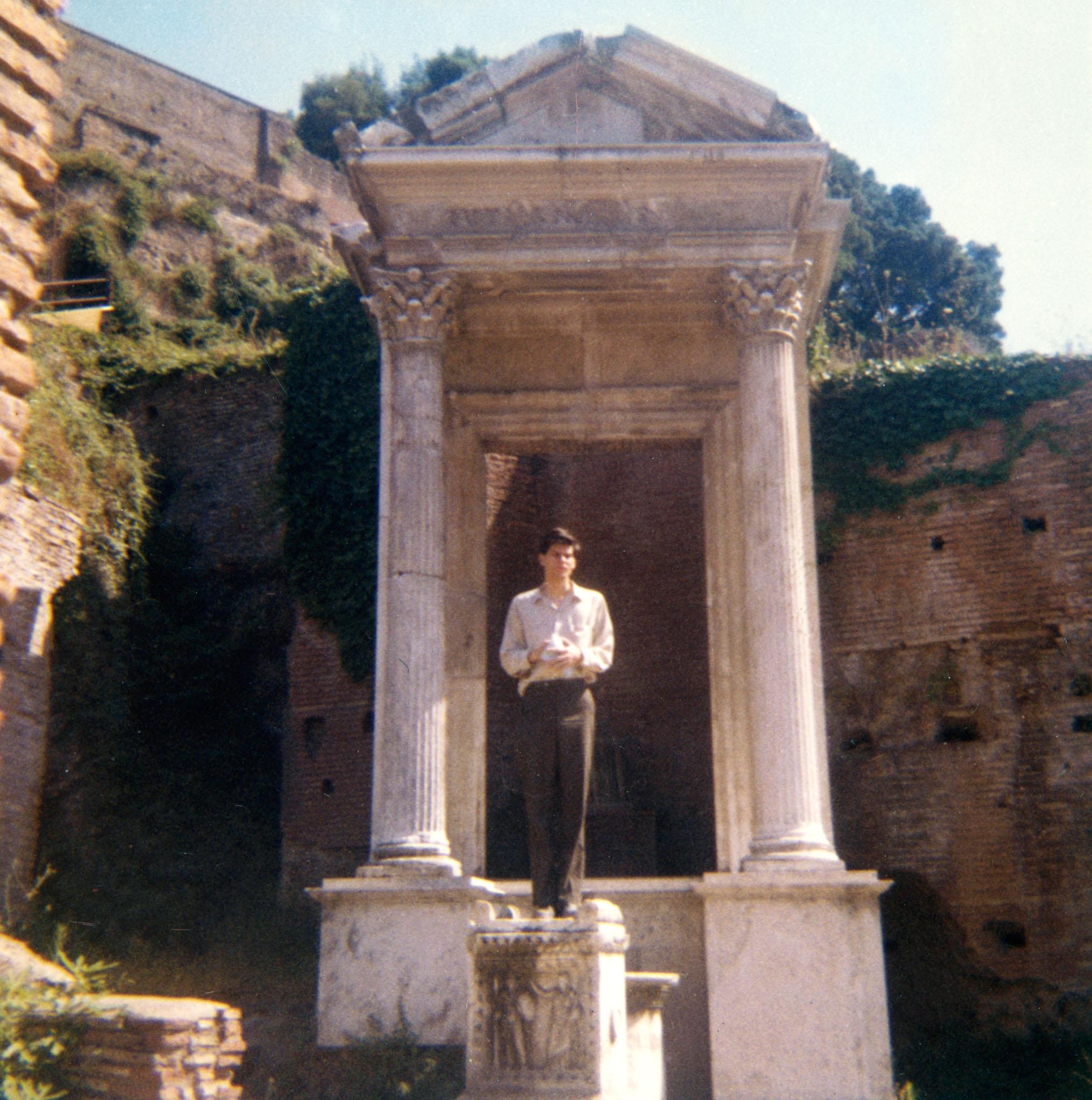 Robert Smithson in Rome standing on a stone pillar