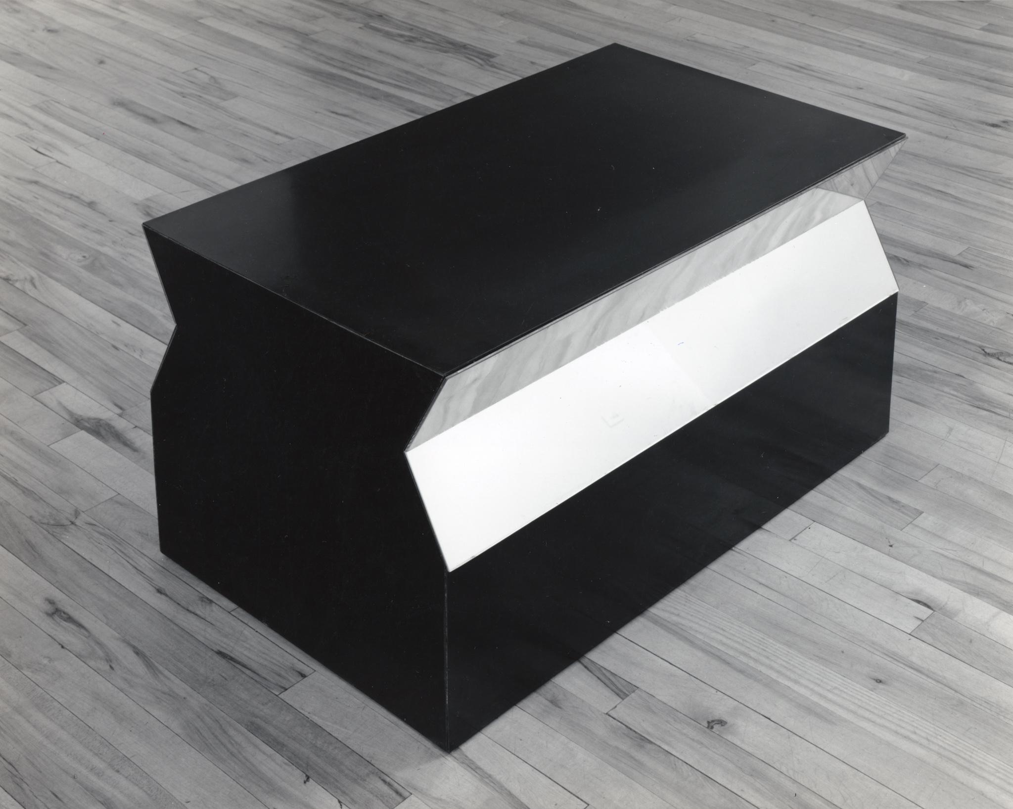 a low black trapezoidal sculpture that sits on the floor