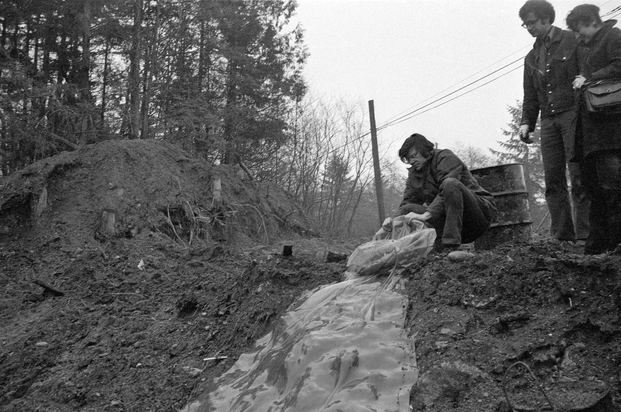 Robert Smithson pouring glue down a muddy hillside