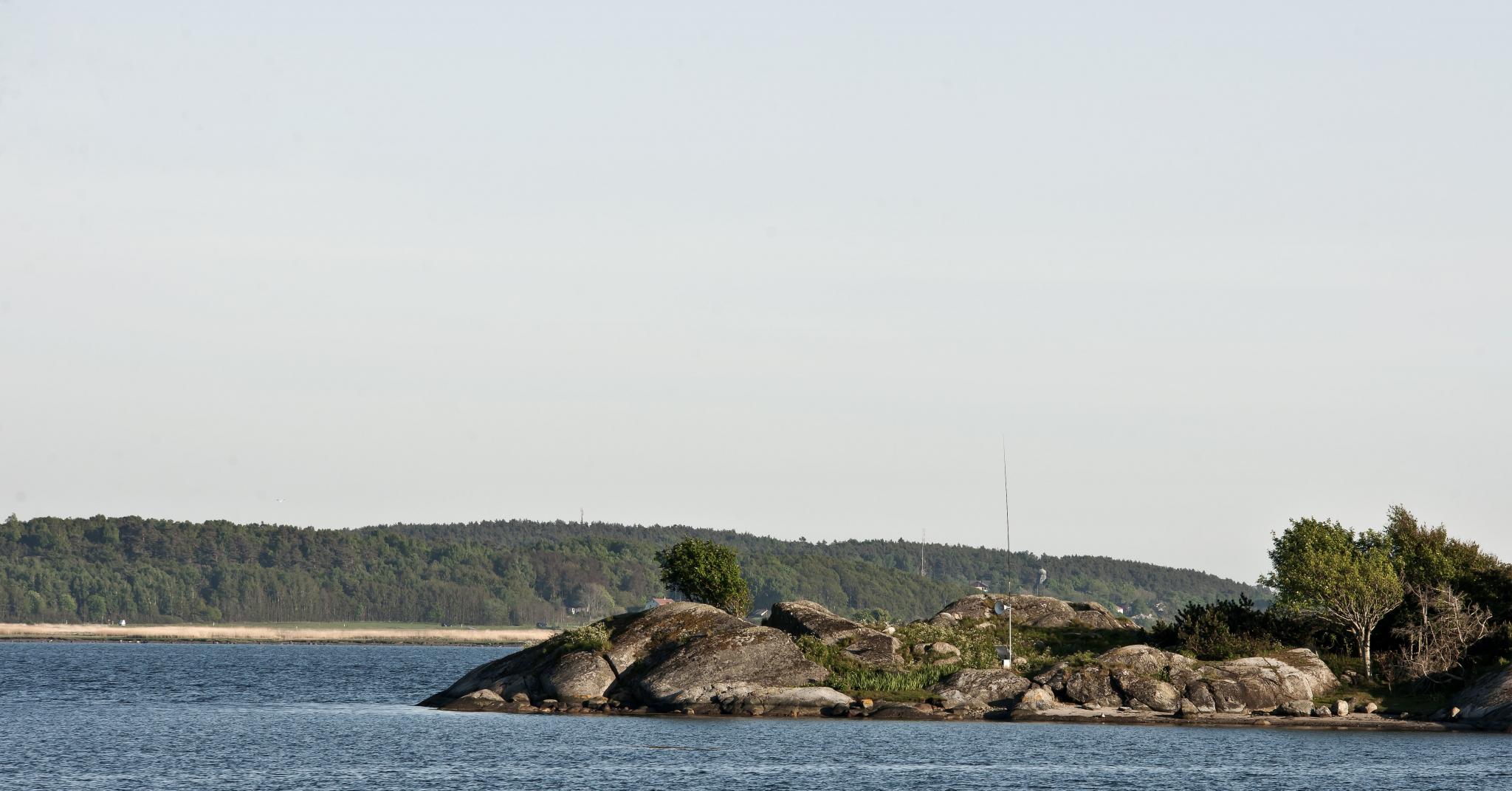 a rocky outcrop surrounded by deep blue sea