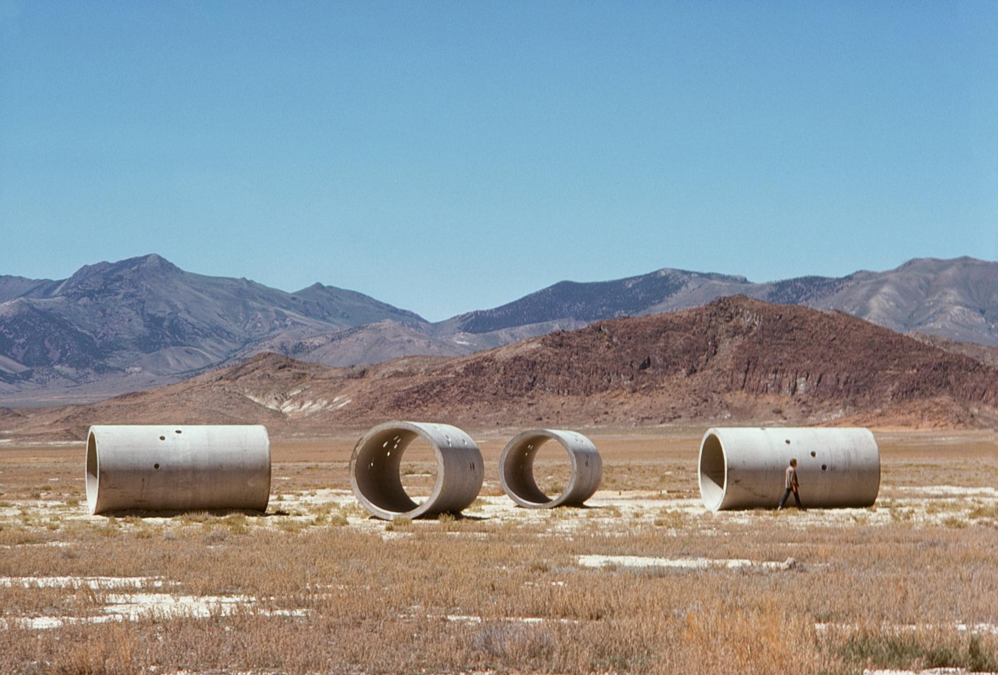four large concrete tunnels in a desert landscape