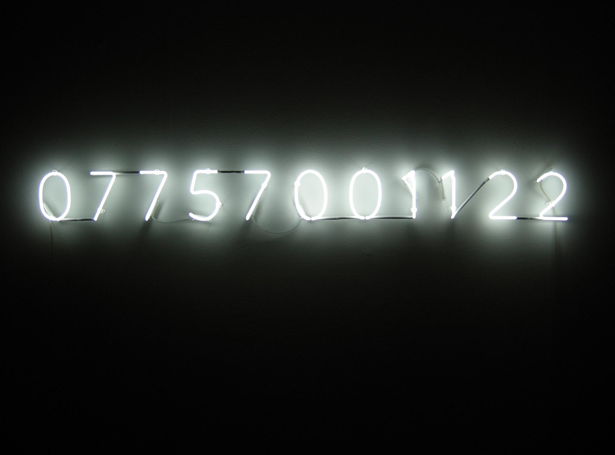 a bright white neon light with the numbers 077757001122
