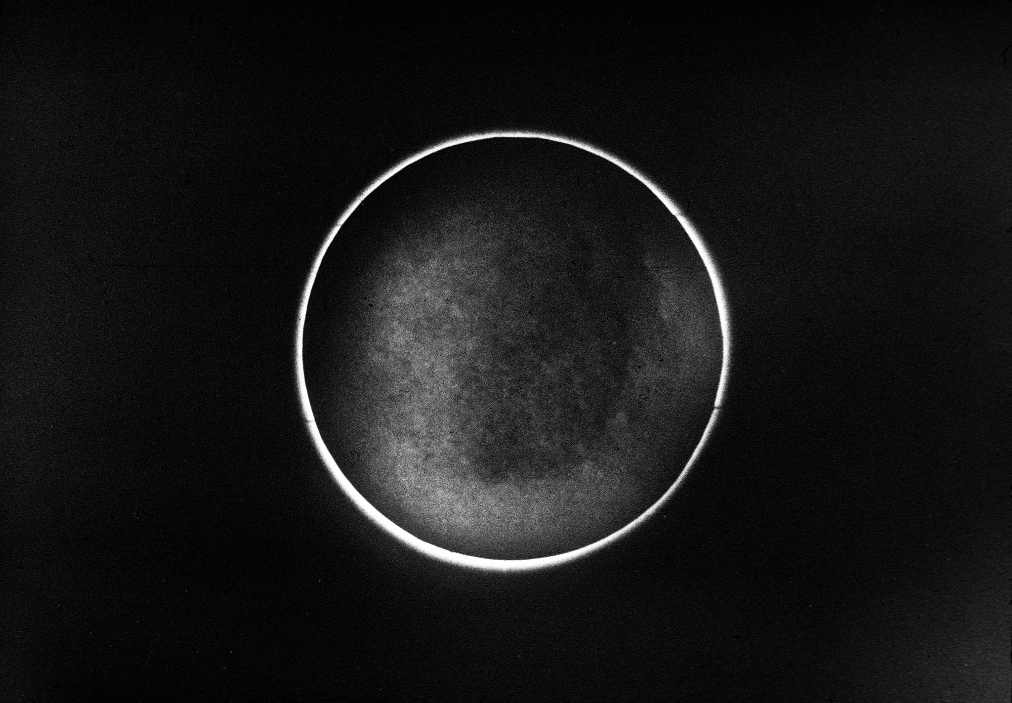 a black circle with a small halo of white light surrounding it