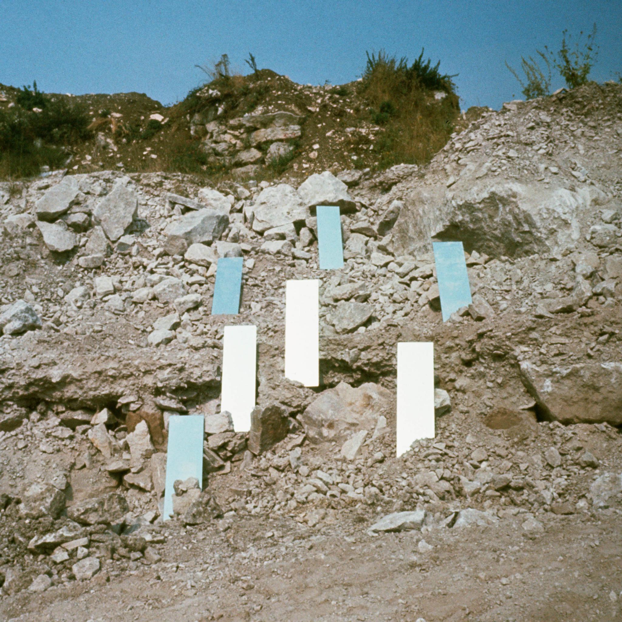 a group of mirrors placed vertically on a rocky hillside