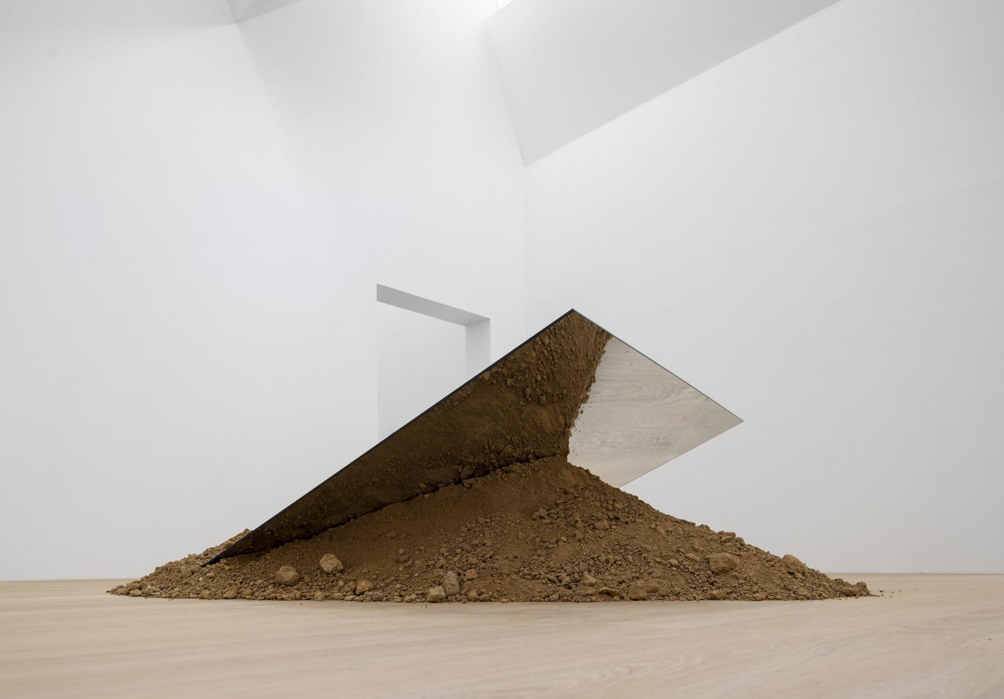 a sculpture in a museum made of glass and soil