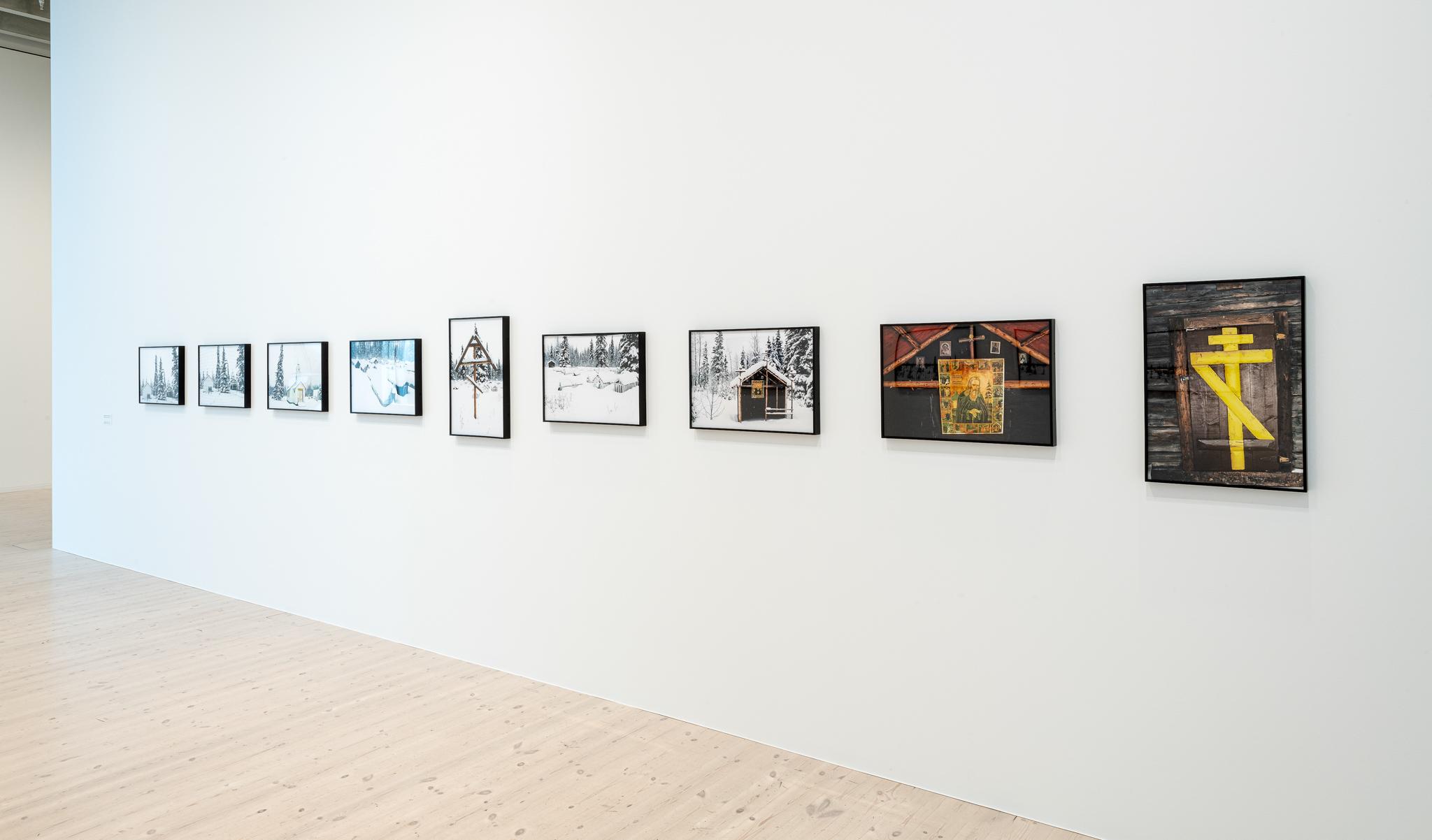 an installation image of nine images installed on a gallery wall