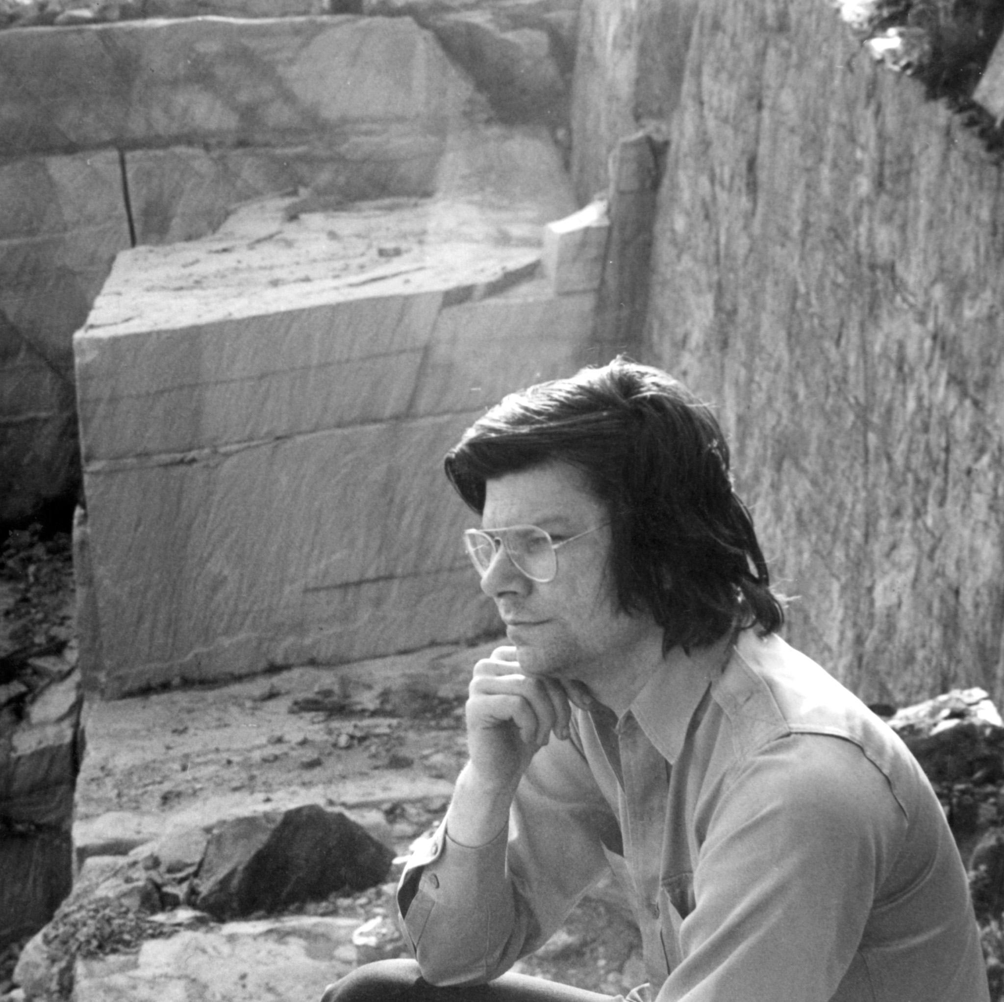 a man sitting pensively in a stone quarry