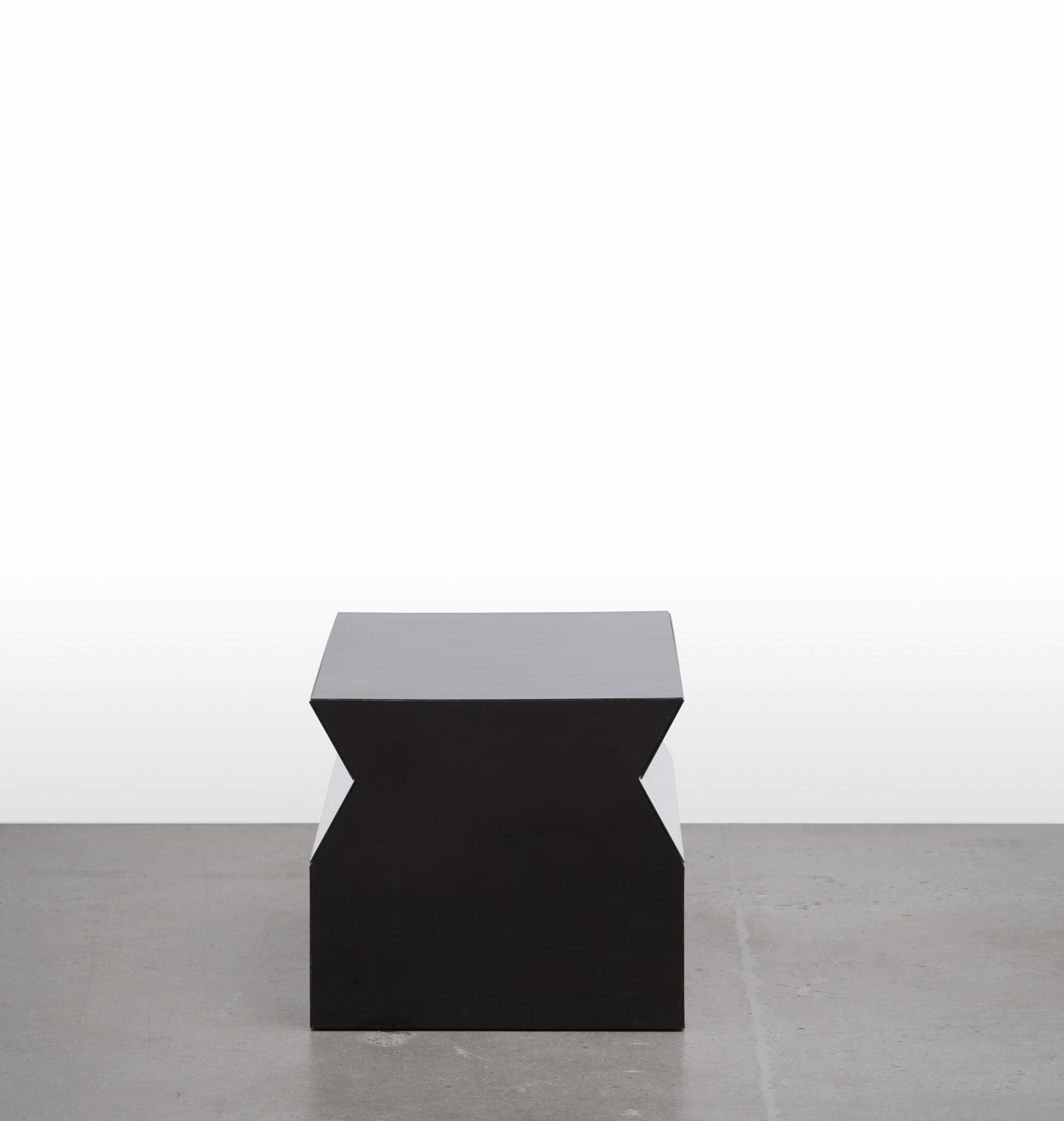 a geometric sculpture made of formica and mirrors sitting on a concrete floor