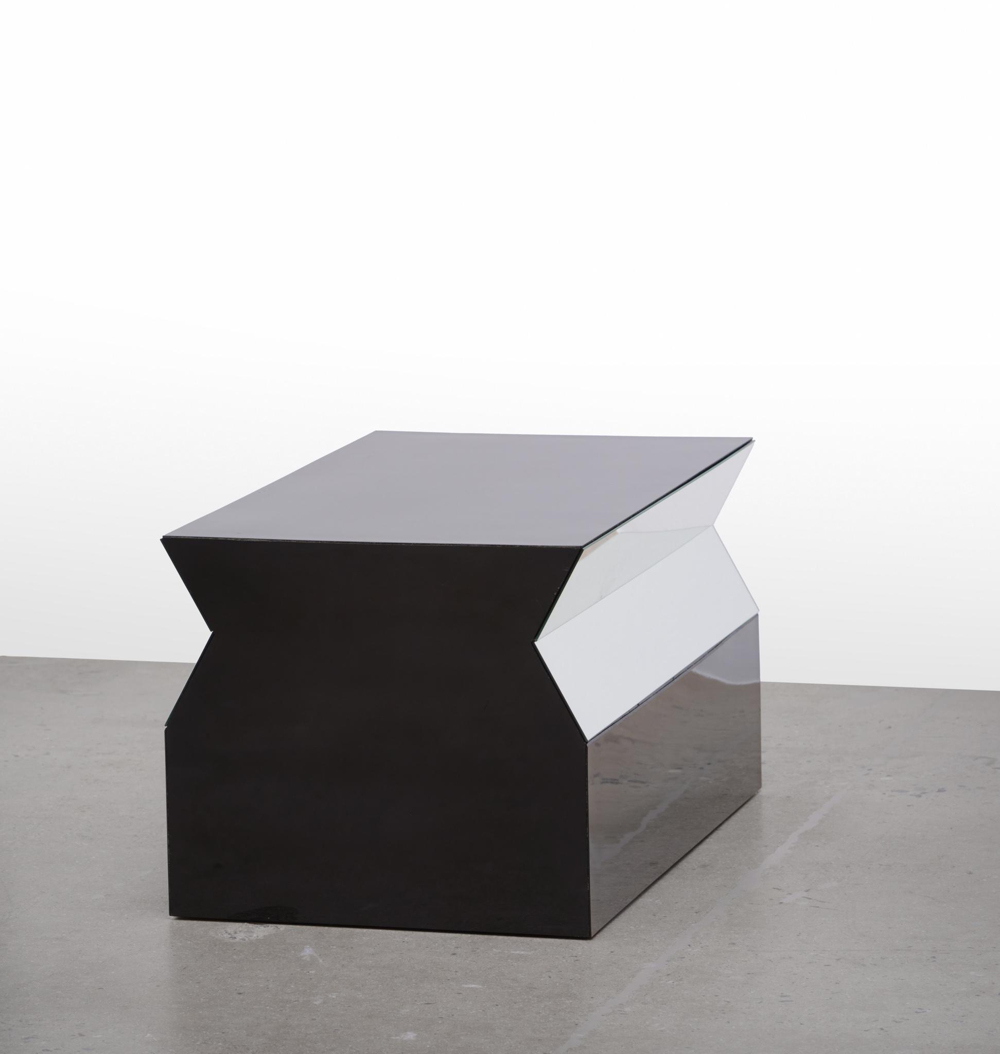 a geometric sculpture made of formica and mirrors sitting on a concrete floor