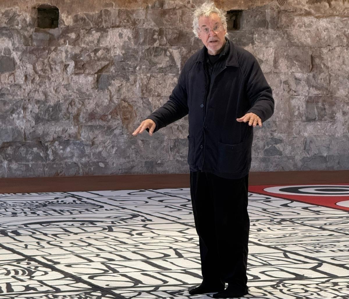 an artist talking while standing on a carpet