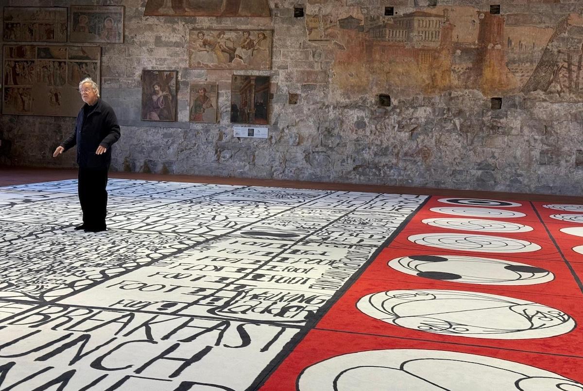 an artist talking while standing on a carpet