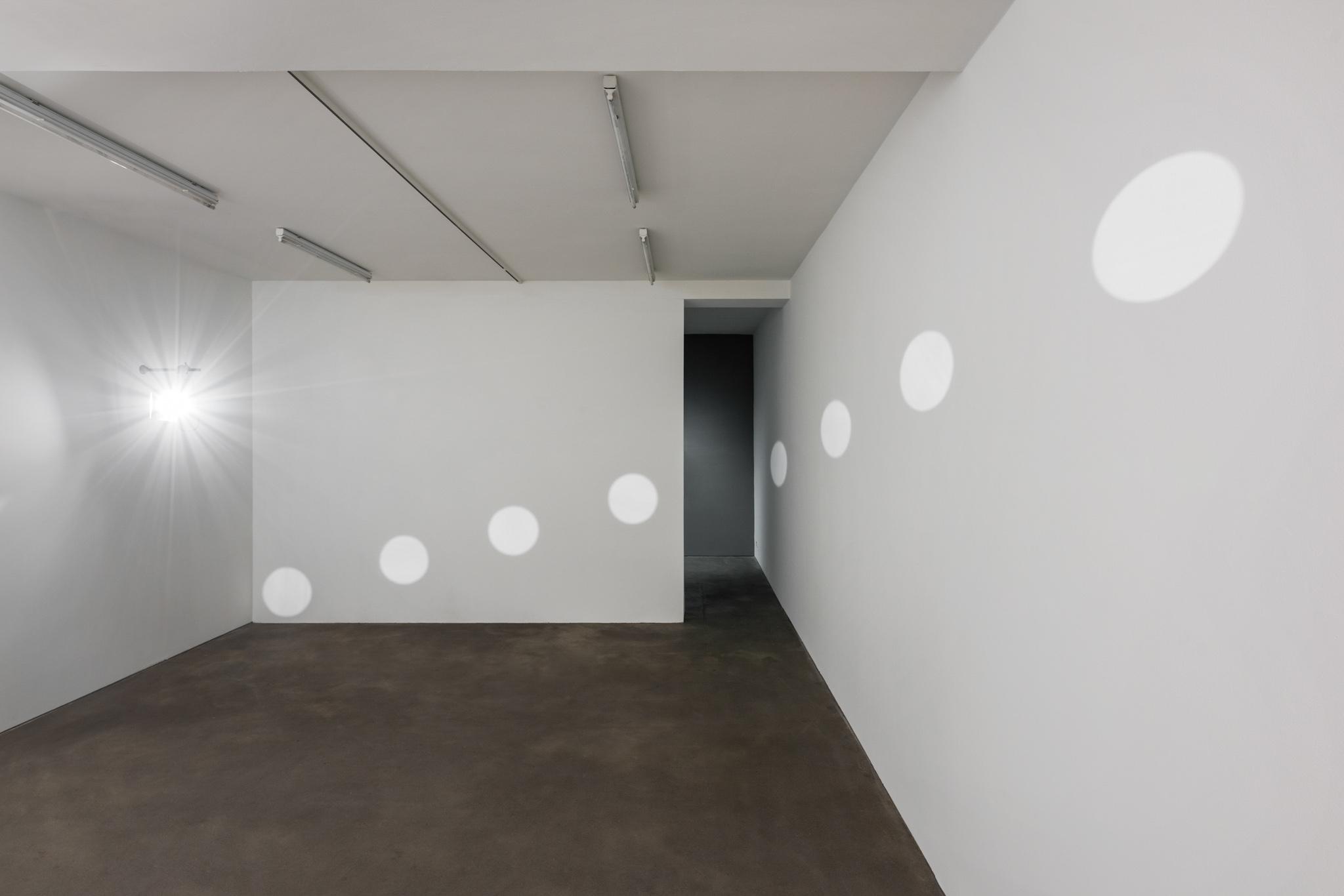 a room with light reflected from a diagonal line of mirrors