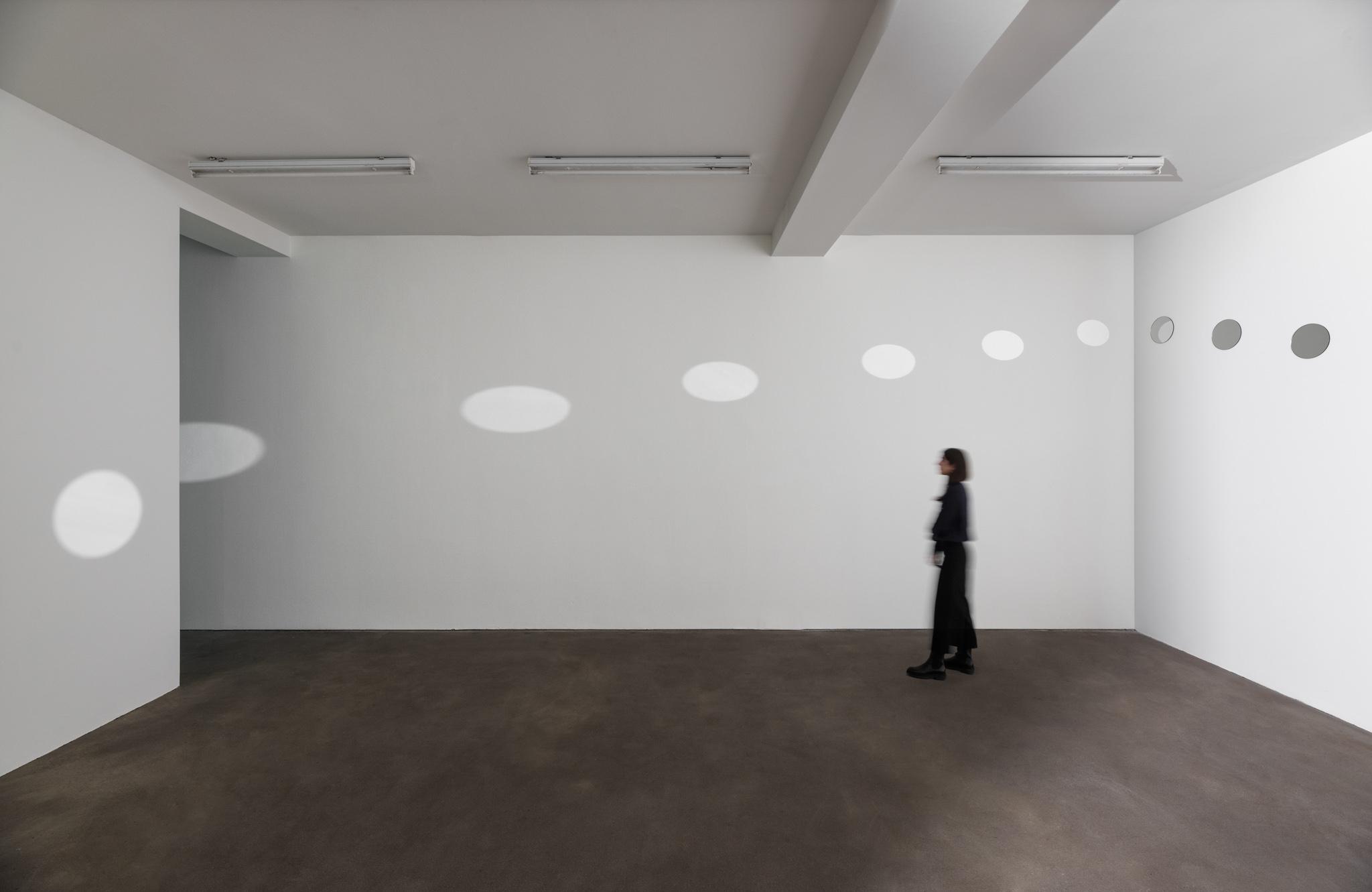 a room with light reflected from a diagonal line of mirrors