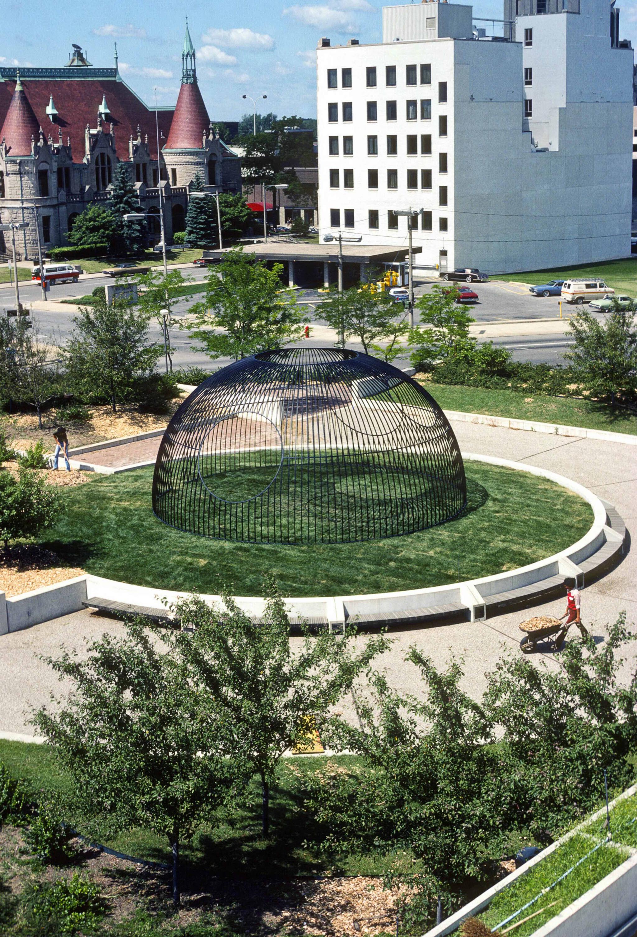 an outdoor sculpture made of steel bars in a hemisphere