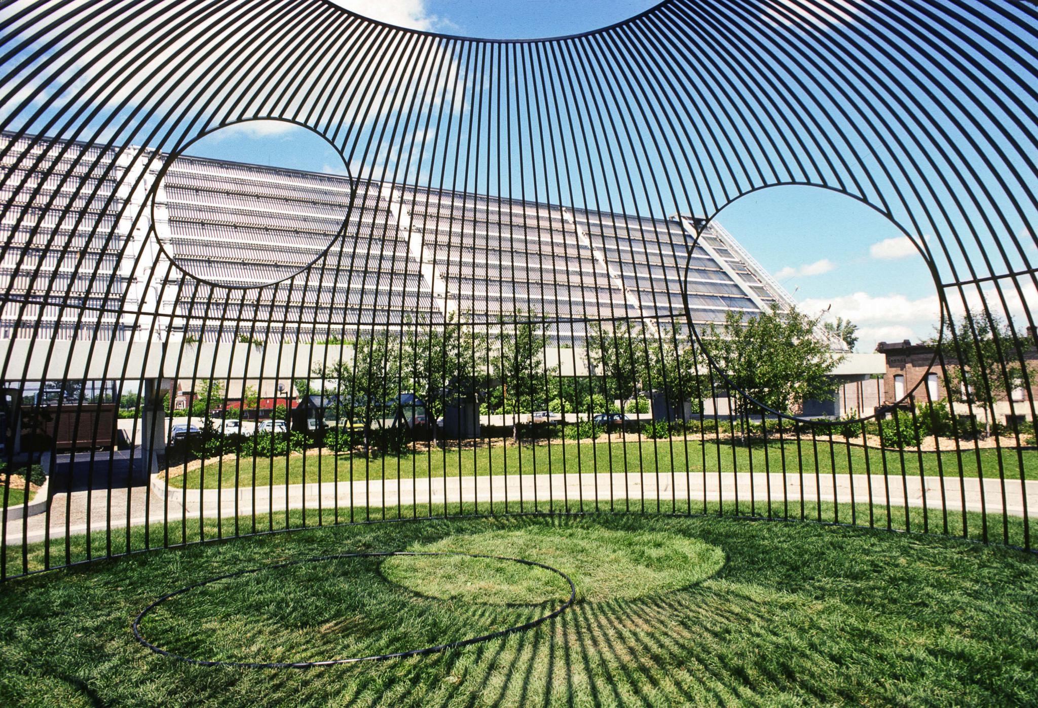 an outdoor sculpture made of steel bars in a hemisphere