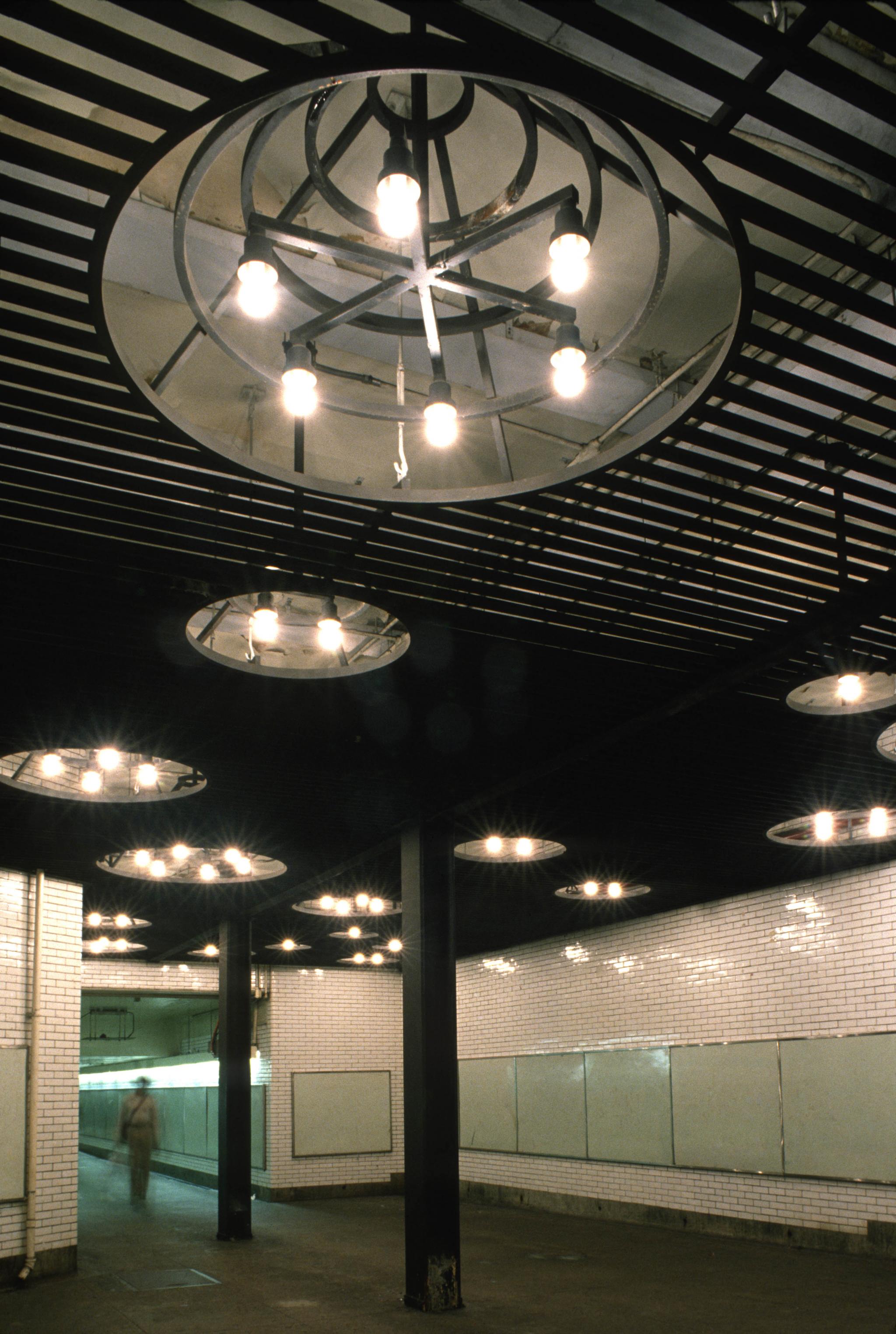 steel ceiling-light sculpture installed in a subway passageway