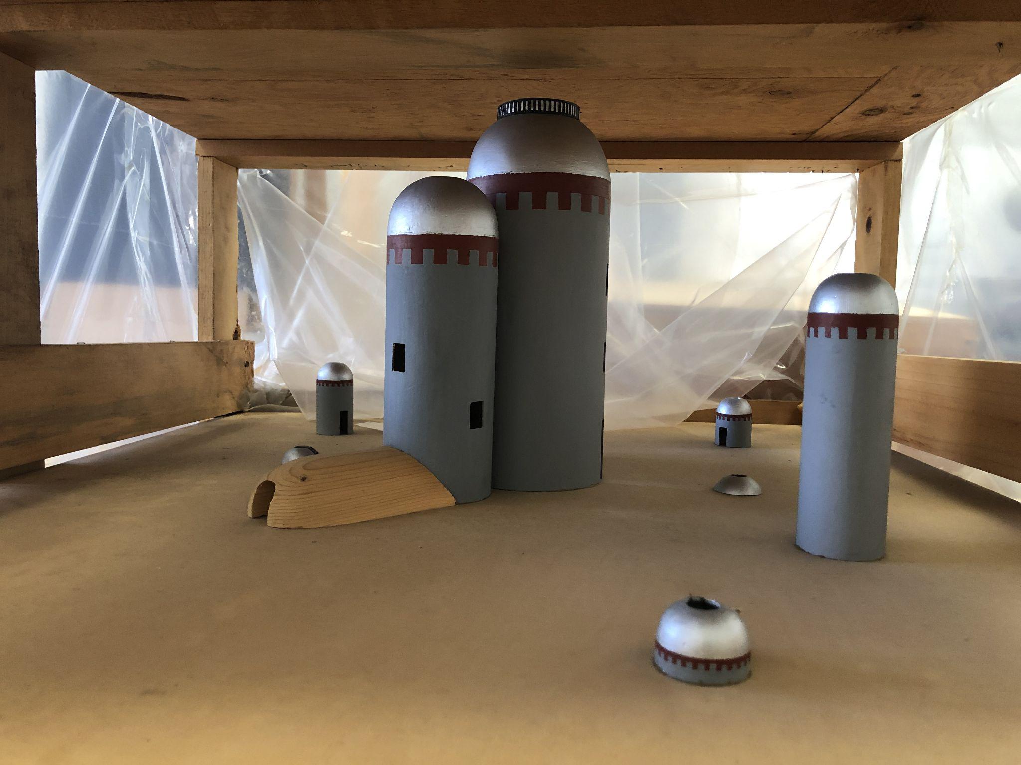 model (seen in a packing crate) for an outdoor sculpture proposal showing silo-like forms
