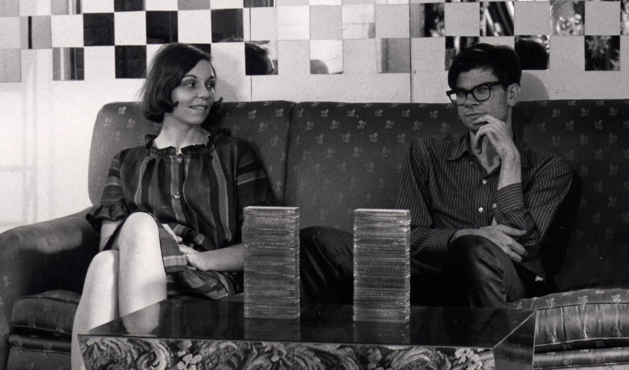 Black and white photograph of Nancy Holt and Robert Smithson sitting on a couch
