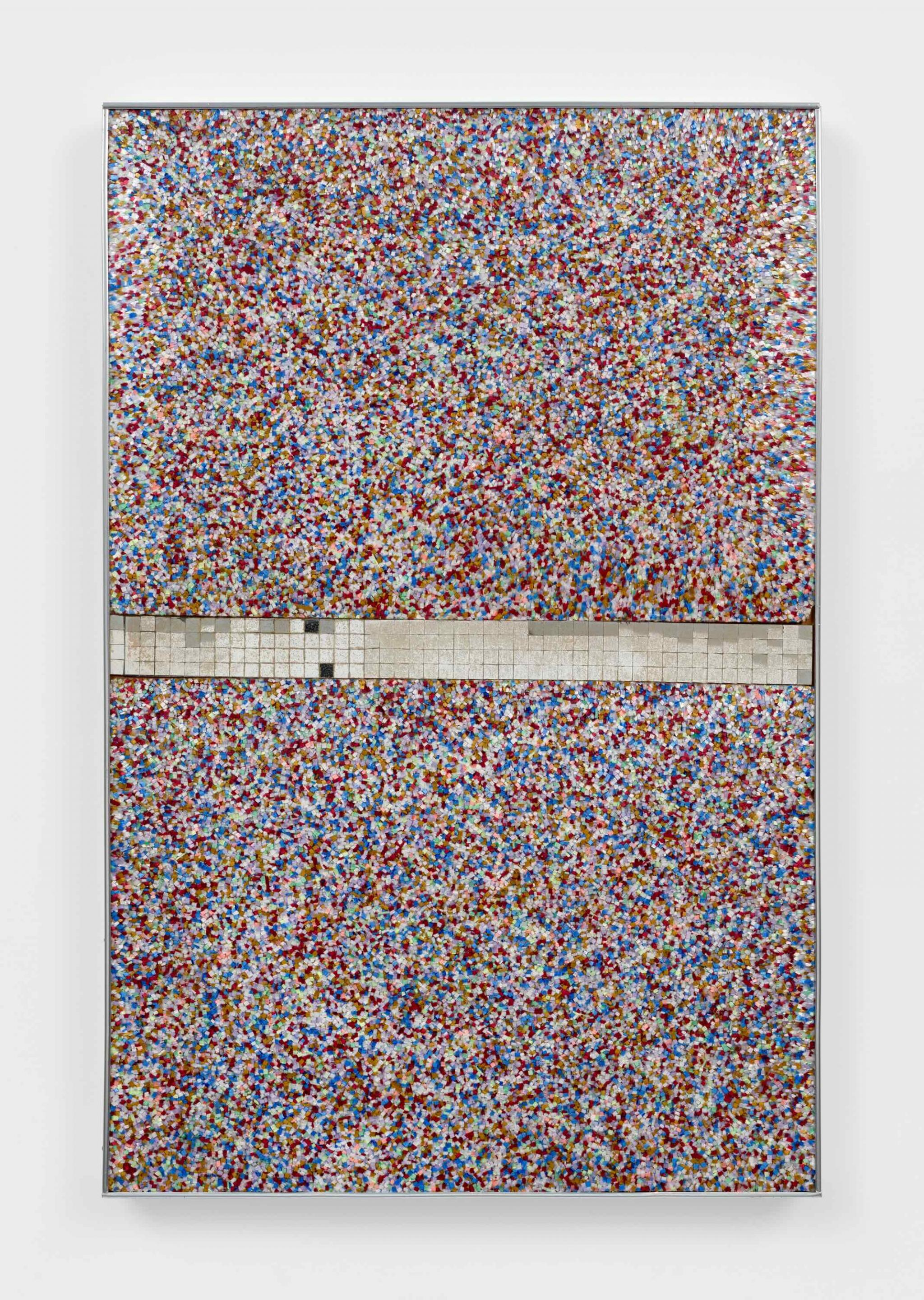 a wall based sculpture made of  brightly colored Plexiglas fragments and mirror tiles