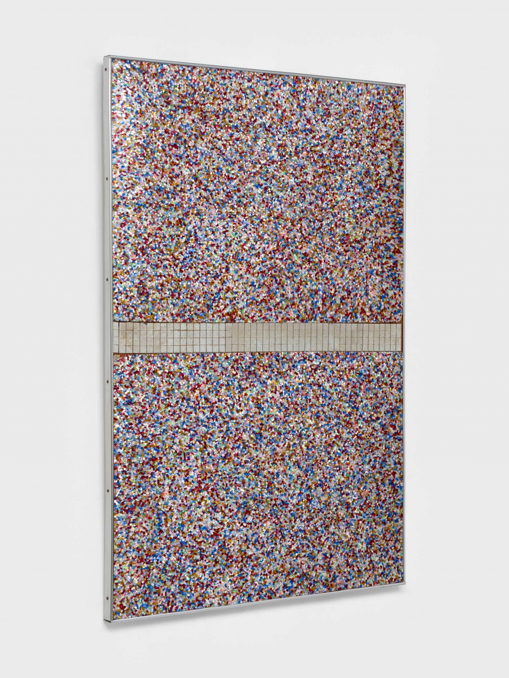 a wall based sculpture made of  brightly colored Plexiglas fragments and mirror tiles