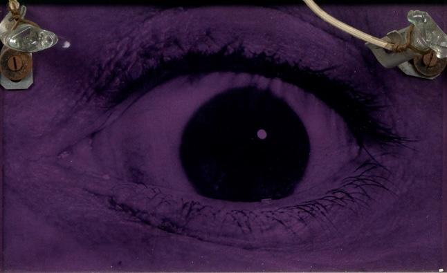 a wall mounted sculpture with an eye at the center