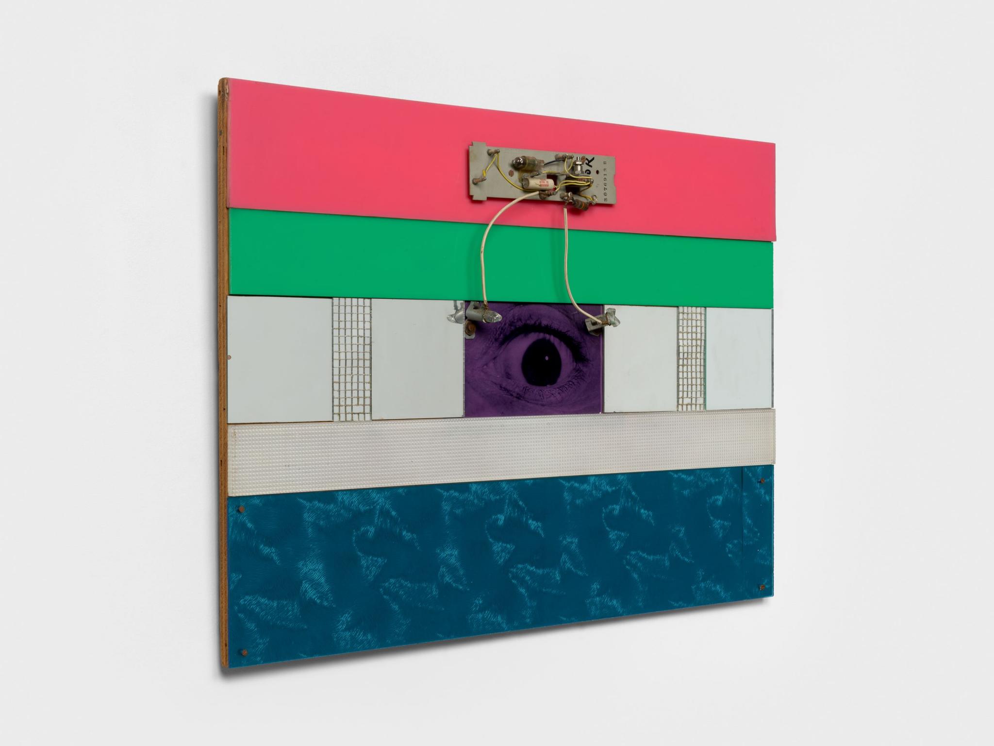 a wall mounted sculpture with an eye at the center