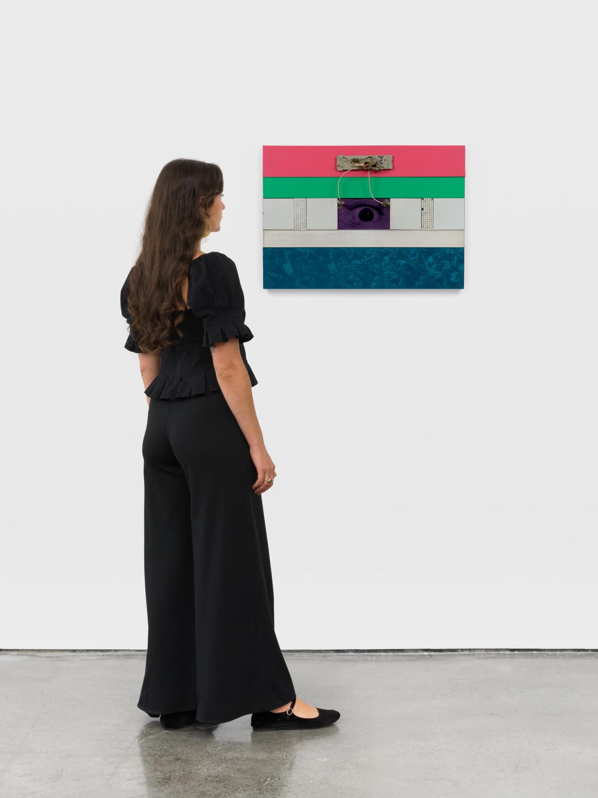 a wall mounted sculpture with an eye at the center