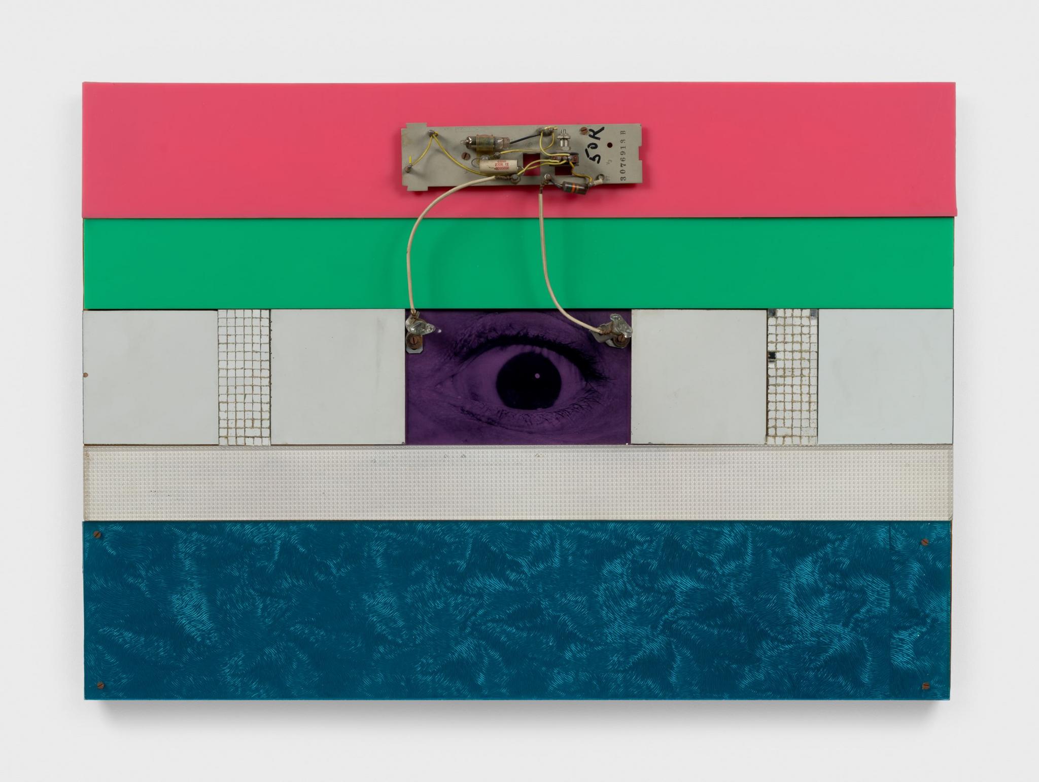 a wall mounted sculpture with an eye at the center